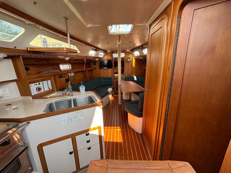 Slide: The Image of Interior of a 1998 Catalina 320 sailboat with wood finish and cozy seating area. - 43