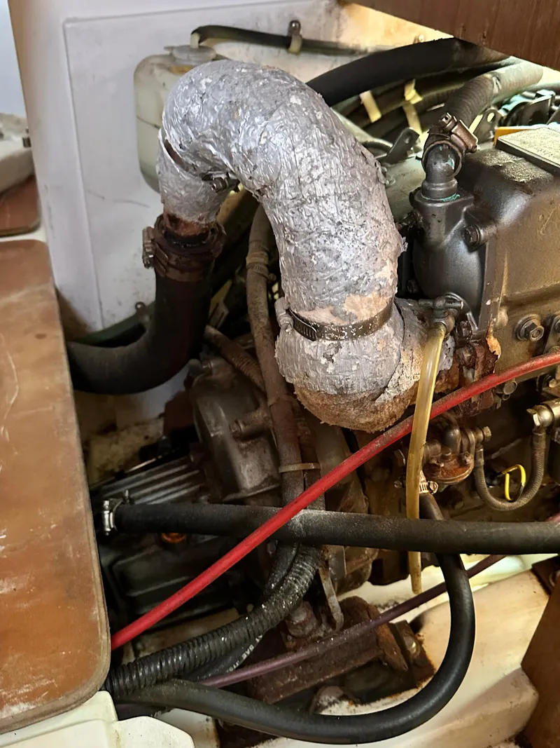 Slide: The Image of Engine compartment of a 1998 Catalina 320 sailboat, showing pipes and mechanical components. - 46