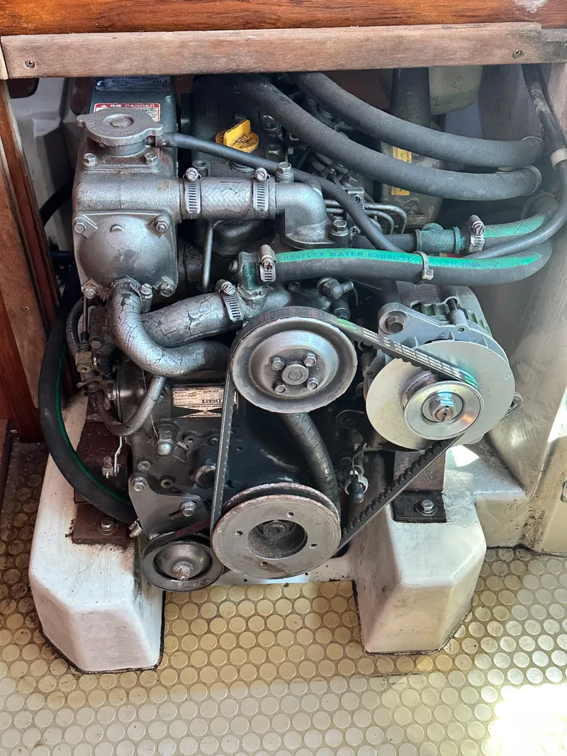 Slide: The Image of Engine of a 1998 Catalina 320 sailboat, featuring belts and hoses. - 47