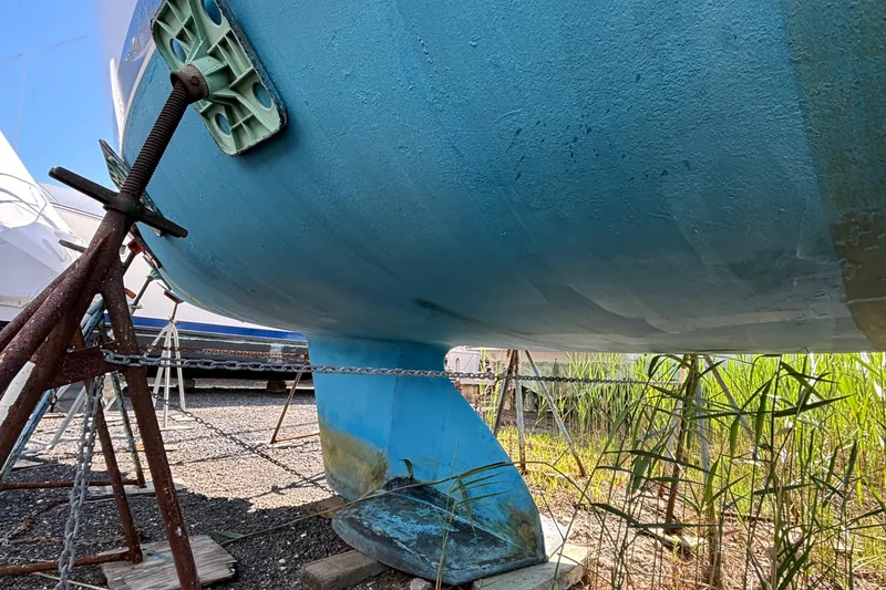 Slide: The Image of 1998 Catalina 320 sailboat hull on stands, showing keel and rudder. - 7