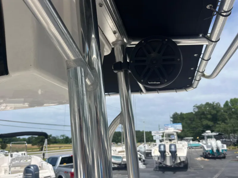 Slide: The Image of 2019 Carolina Skiff 238 DLV boat with T-top and speaker, parked in a marina. - 14