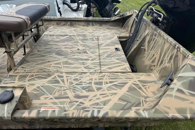 Slide: The Image of 2025 Crestliner 1860 Retriever CC Tunnel boat with camouflage design, parked outside dealership. - 4