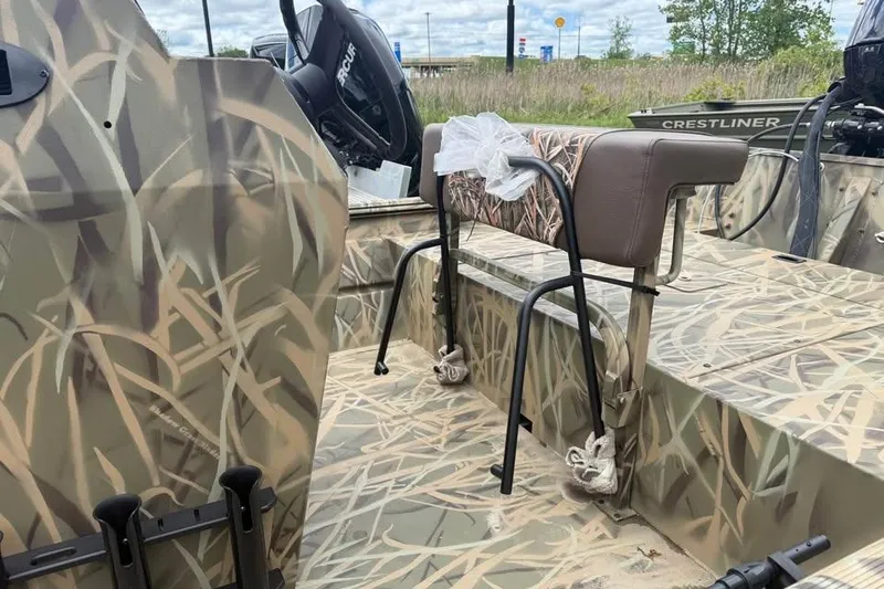 Slide: The Image of 2025 Crestliner 1860 Retriever CC Tunnel boat with Mercury engine, parked outside dealership. - 5