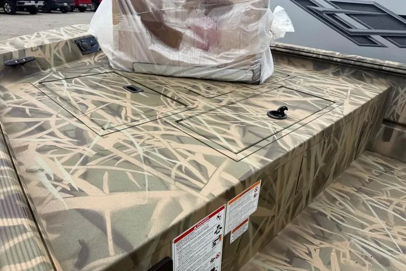 Slide: The Image of 2025 Crestliner 1860 Retriever CC Tunnel boat with camouflage design and steering console. - 7