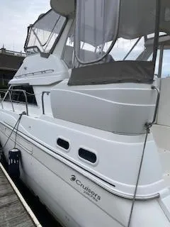 Slide: The Image of 2003 Cruisers Yachts 3750 Motoryacht docked, featuring sleek white design and spacious upper deck. - 3