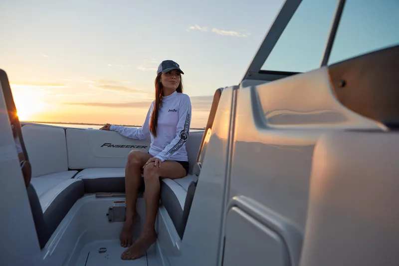 Slide: The Image of Woman relaxing on a 2026 Finseeker 240 DC boat at sunset. - 4