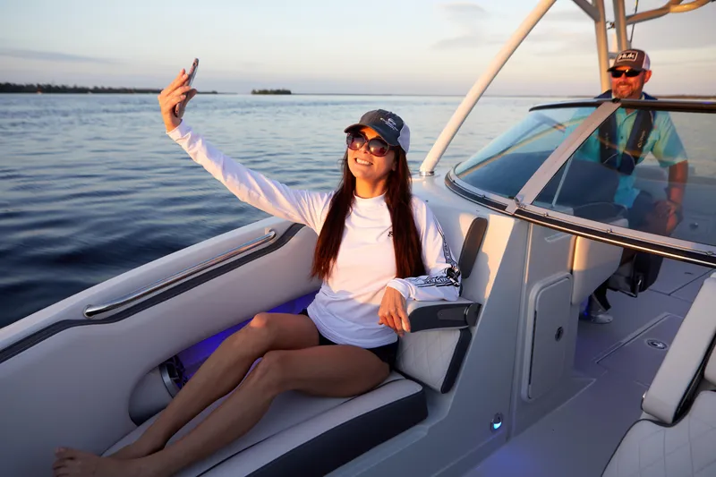Slide: The Image of Woman taking selfie on 2026 Finseeker 240 DC boat at sunset. - 6