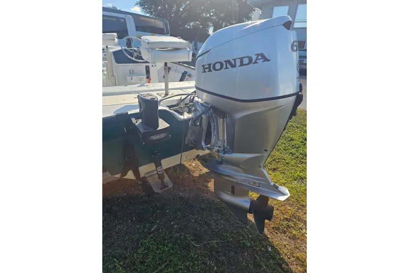 Slide: The Image of 1999 Aqua Force Fish Hawk with Honda outboard motor on grassy area. - 10
