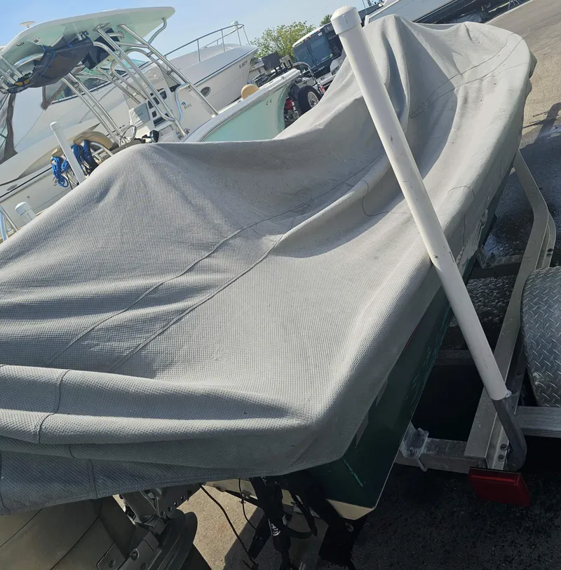 Slide: The Image of 1999 Aqua Force Fish Hawk boat covered on a trailer in a marina. - 4