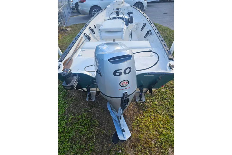 Slide: The Image of 1999 Aqua Force Fish Hawk boat with 60 HP outboard motor, parked on grass. - 8