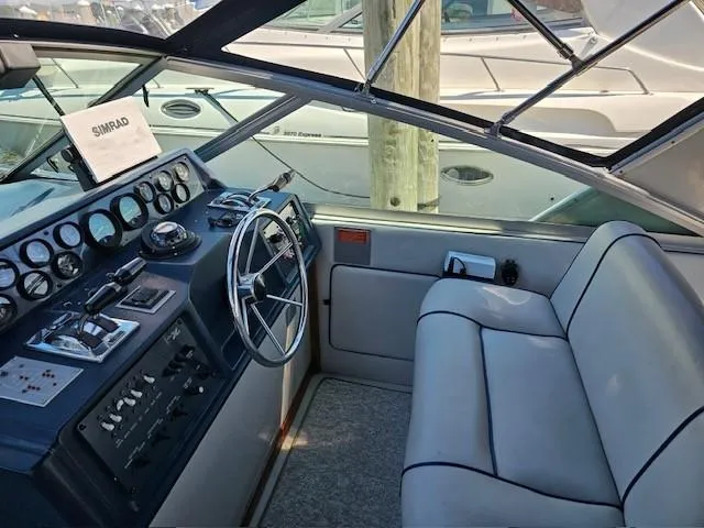 Slide: The Image of 1988 Sea Ray 340 Sundancer helm with steering wheel and control panel. - 12