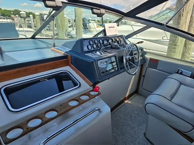 Slide: The Image of 1988 Sea Ray 340 Sundancer cockpit with steering wheel, gauges, and seating. - 13