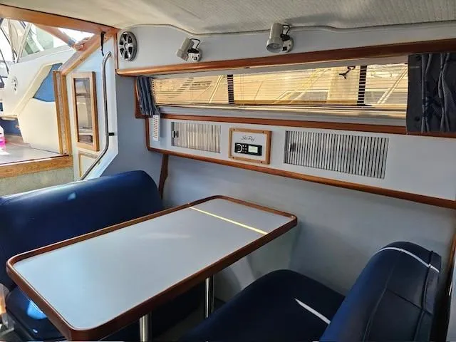 Slide: The Image of Interior of 1988 Sea Ray 340 Sundancer with dining area and blue seating. - 16