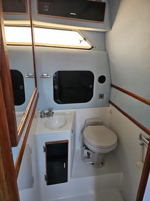 Slide: The Image of 1988 Sea Ray 340 Sundancer bathroom with sink, toilet, and storage cabinets. - 20