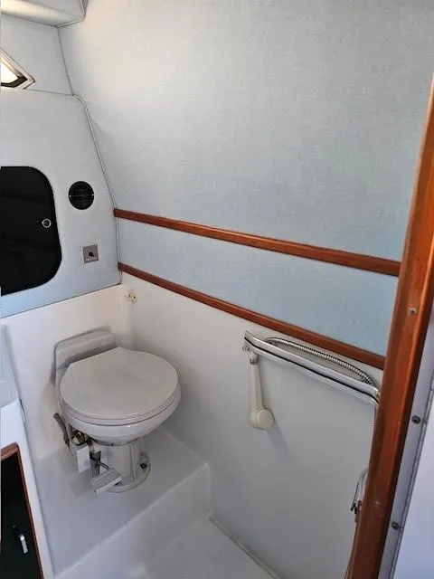 Slide: The Image of 1988 Sea Ray 340 Sundancer boat bathroom with toilet and wooden trim. - 21