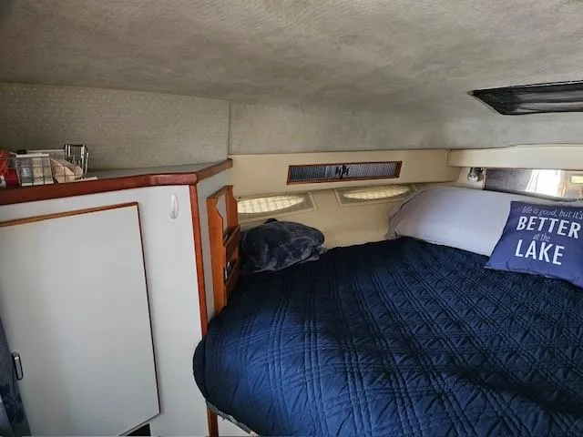 Slide: The Image of Cozy cabin interior of 1988 Sea Ray 340 Sundancer with bed and storage. - 25