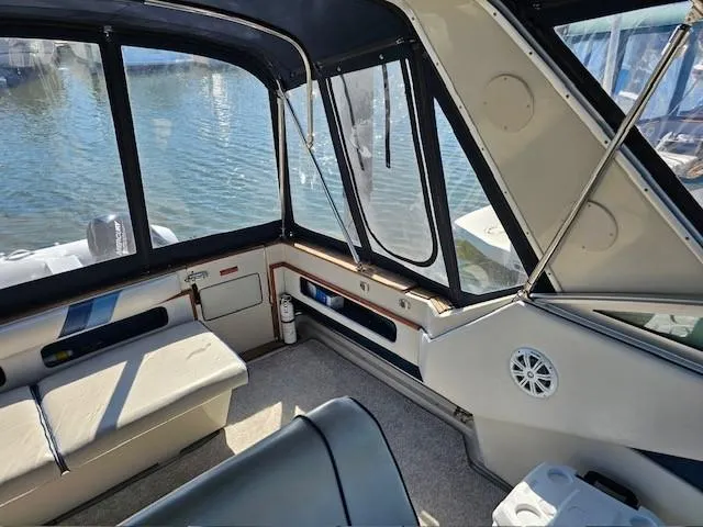 Slide: The Image of 1988 Sea Ray 340 Sundancer interior with seating, windows, and water view. - 6