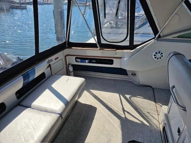 Slide: The Image of 1988 Sea Ray 340 Sundancer interior with seating, windows, and water view. - 7