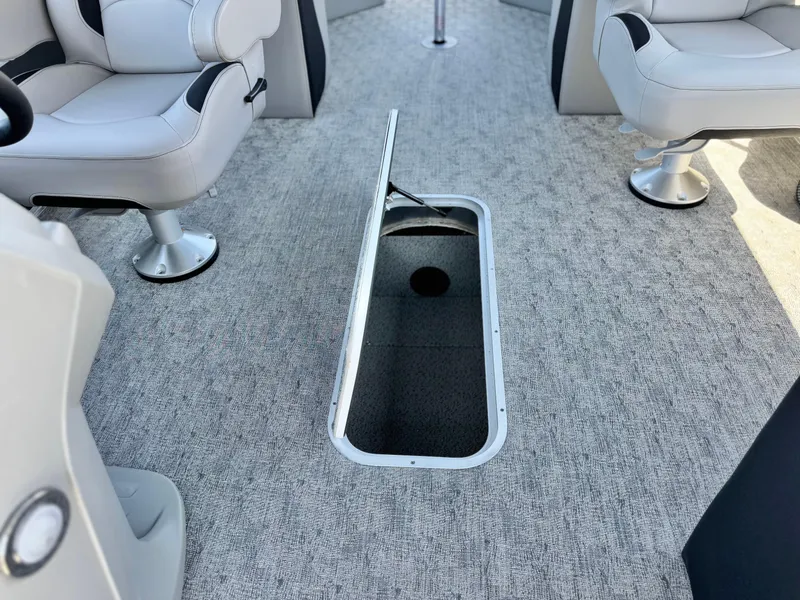 Slide: The Image of 2025 Berkshire 22RFX LE boat interior with open storage compartment and cushioned seating. - 14