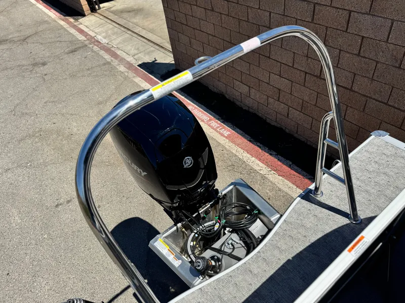 Slide: The Image of 2025 Berkshire 22RFX LE boat with motor and railing, parked on pavement. - 16