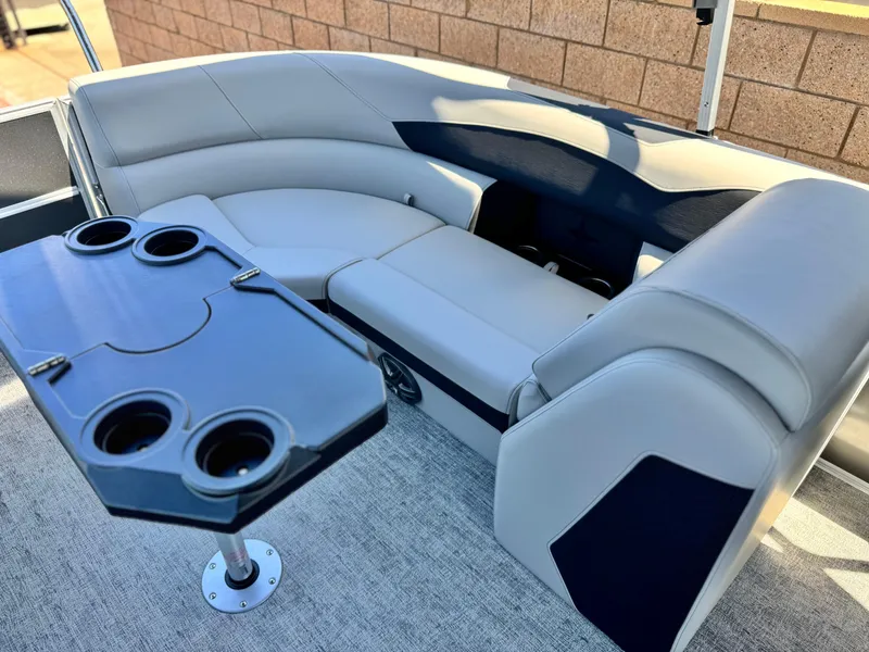 Slide: The Image of 2025 Berkshire 22RFX LE boat interior with gray seating and cupholder table. - 18