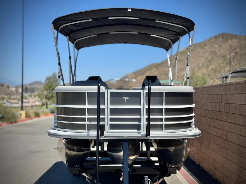 Slide: The Image of 2025 Berkshire 22RFX LE pontoon boat with canopy, parked on a sunny day. - 2
