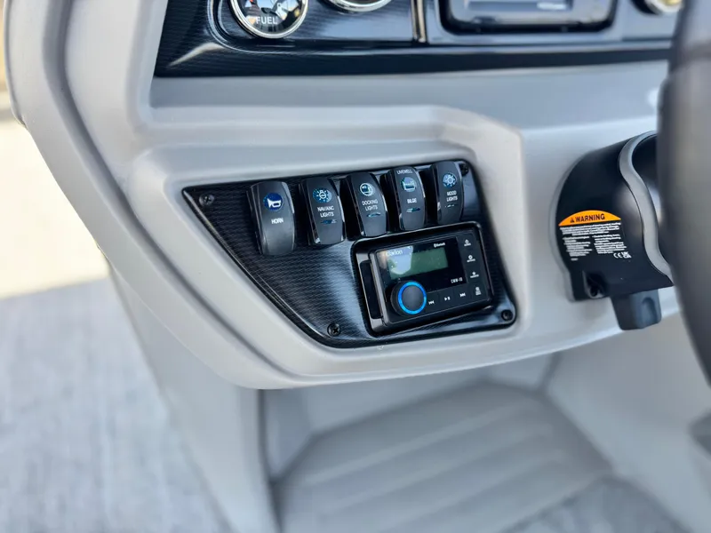 Slide: The Image of Control panel of 2025 Berkshire 22RFX LE boat with switches and display. - 23