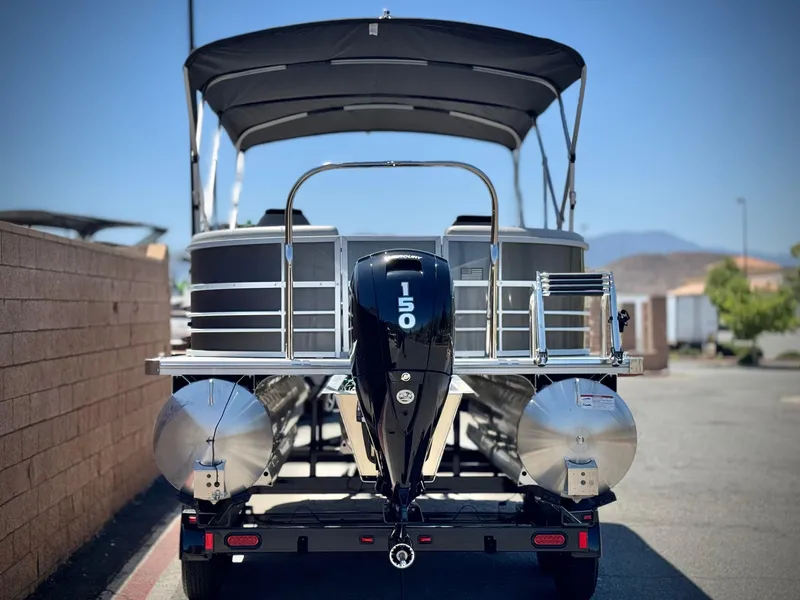 Slide: The Image of 2025 Berkshire 22RFX LE pontoon boat with 150 HP engine, parked on a trailer. - 5