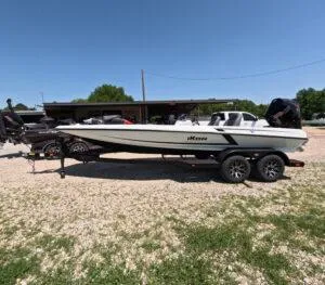 The Image of 2025 iKon VLE21 boat on trailer, parked outdoors under clear blue sky. - 0