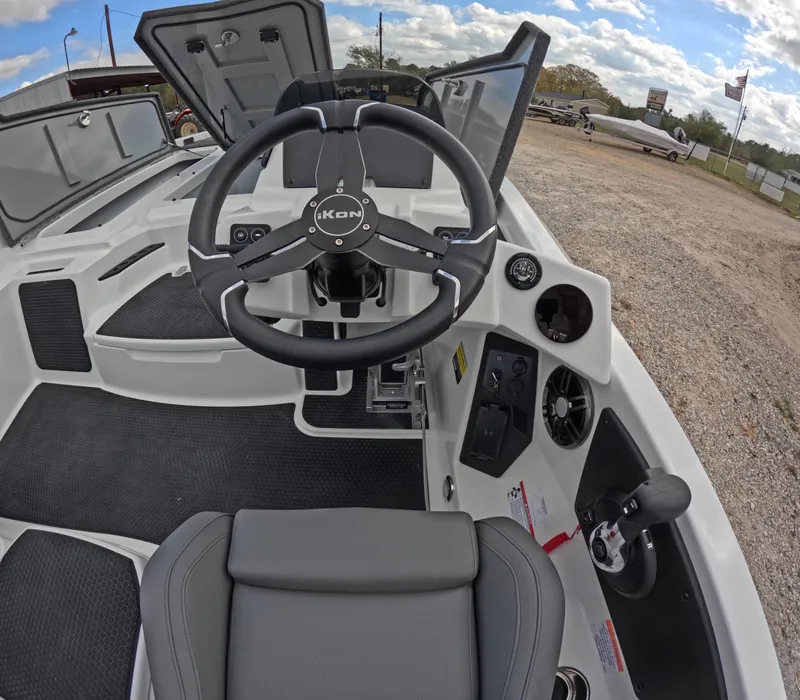 Slide: The Image of 2025 iKon VLE21 boat cockpit with steering wheel and control panel, parked outdoors. - 1