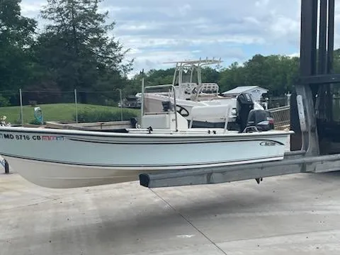 Slide: The Image of 2009 May-Craft 1700 Skiff on trailer, parked outdoors, with trees and cloudy sky in background. - 2