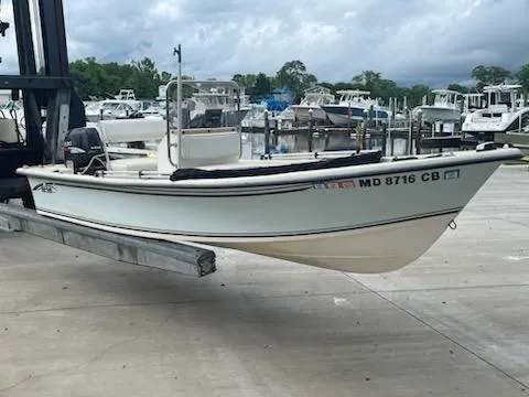 Slide: The Image of 2009 May-Craft 1700 Skiff boat on lift at marina, surrounded by other boats. - 3