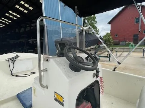 Slide: The Image of 2009 May-Craft 1700 Skiff boat console with steering wheel and controls. - 7