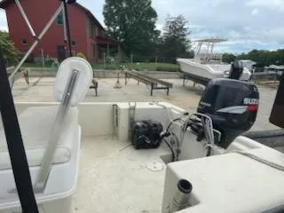 Slide: The Image of 2009 May-Craft 1700 Skiff boat with Suzuki outboard motor in a yard setting. - 8