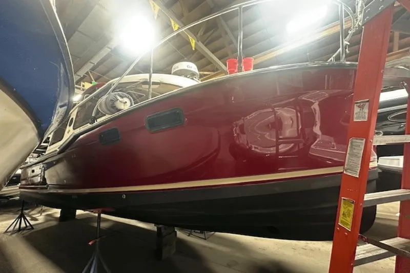 Slide: The Image of 2019 Ranger R27 LE boat in storage, red hull, indoor lighting. - 1