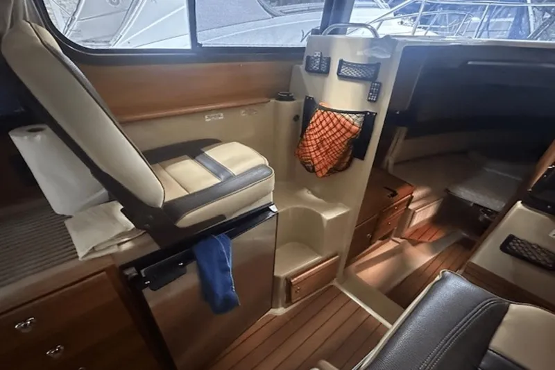 Slide: The Image of 2019 Ranger R27 LE boat interior with seating, storage, and wood flooring. - 12