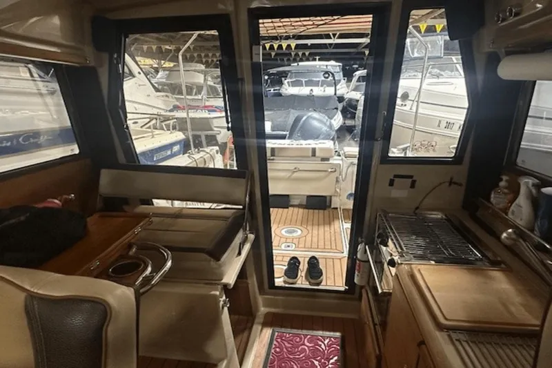 Slide: The Image of Interior view of a 2019 Ranger R27 LE boat with kitchen and seating area. - 14