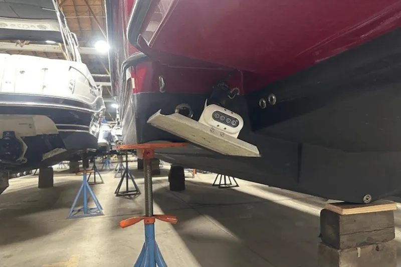 Slide: The Image of 2019 Ranger R27 LE boat in storage, supported by stands, with visible transom and equipment. - 34