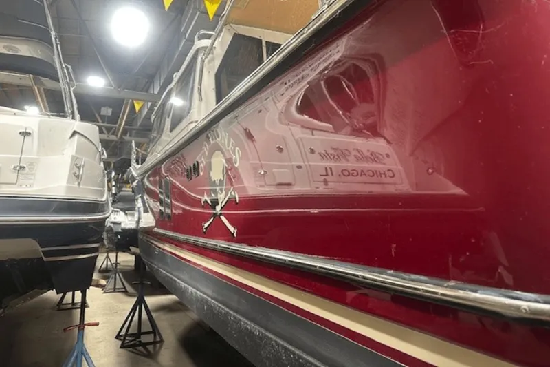 Slide: The Image of 2019 Ranger R27 LE boat in storage, red hull with pirate design, indoor facility. - 36