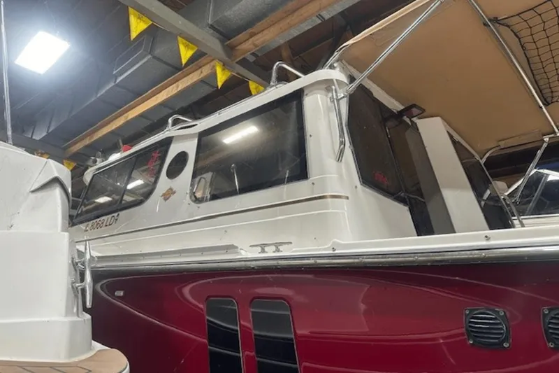 Slide: The Image of 2019 Ranger R27 LE boat in indoor storage, featuring a red and white exterior. - 37