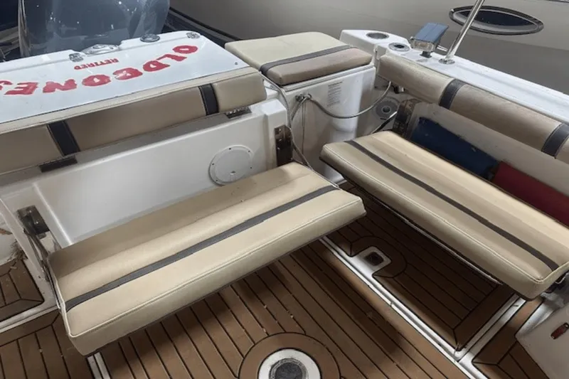 Slide: The Image of 2019 Ranger R27 LE boat interior with beige cushioned seating and wooden flooring. - 5