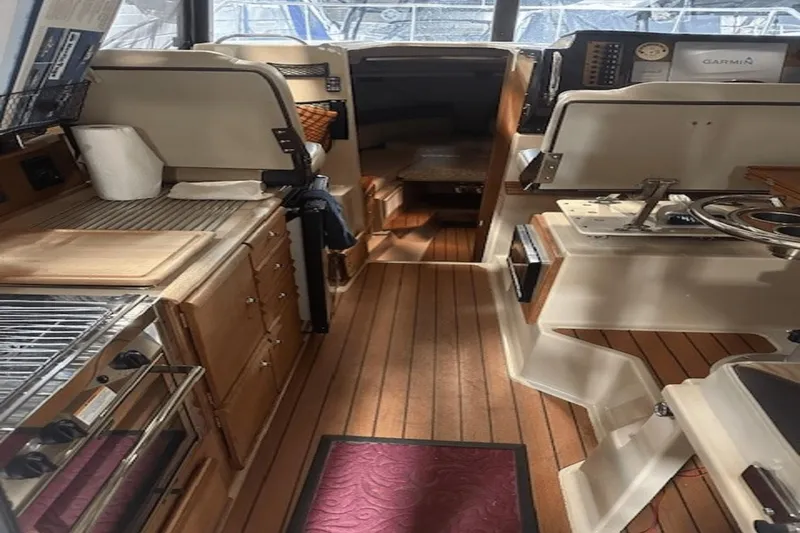 Slide: The Image of 2019 Ranger R27 LE boat interior with wooden flooring and kitchen amenities. - 7