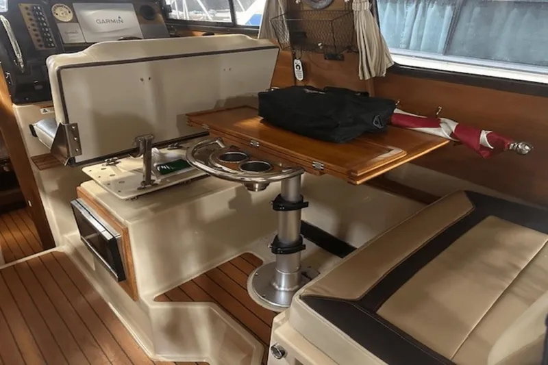 Slide: The Image of 2019 Ranger R27 LE boat interior with wooden table, seating, and navigation equipment. - 8