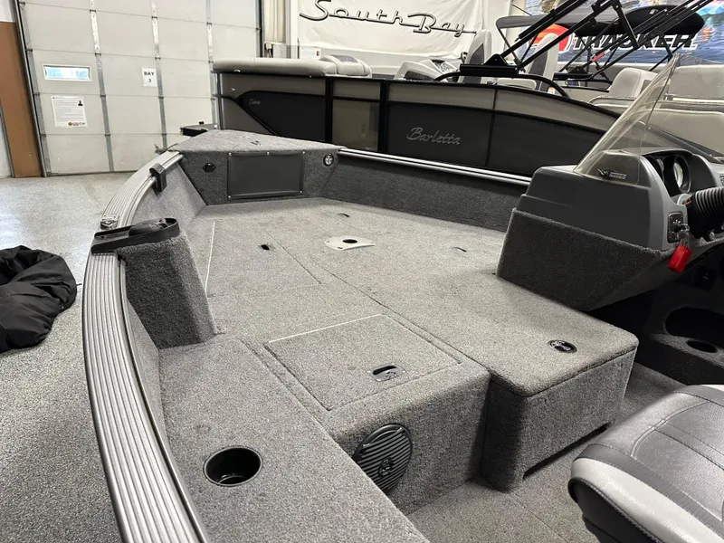 Slide: The Image of 2017 Lund 1675 Impact SS boat interior with gray carpet and storage compartments. - 8