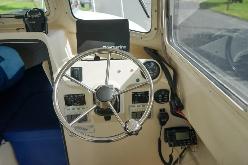 Slide: The Image of 2016 C-Dory 22' Cruiser helm with steering wheel and navigation equipment. - 13