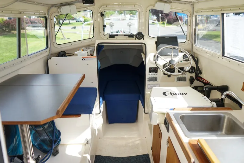 Slide: The Image of Interior of a 2016 C-Dory 22' Cruiser boat with steering wheel and seating area. - 7