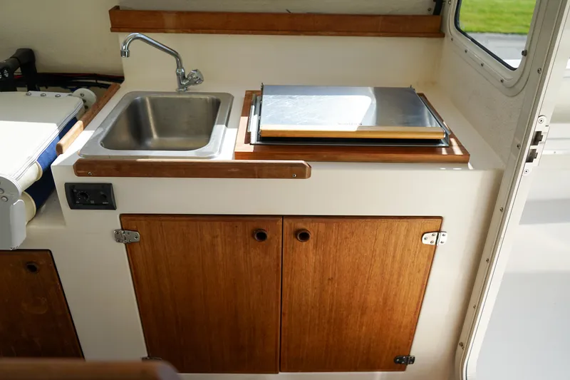 Slide: The Image of 2016 C-Dory 22' Cruiser interior with sink and wooden cabinetry. - 8