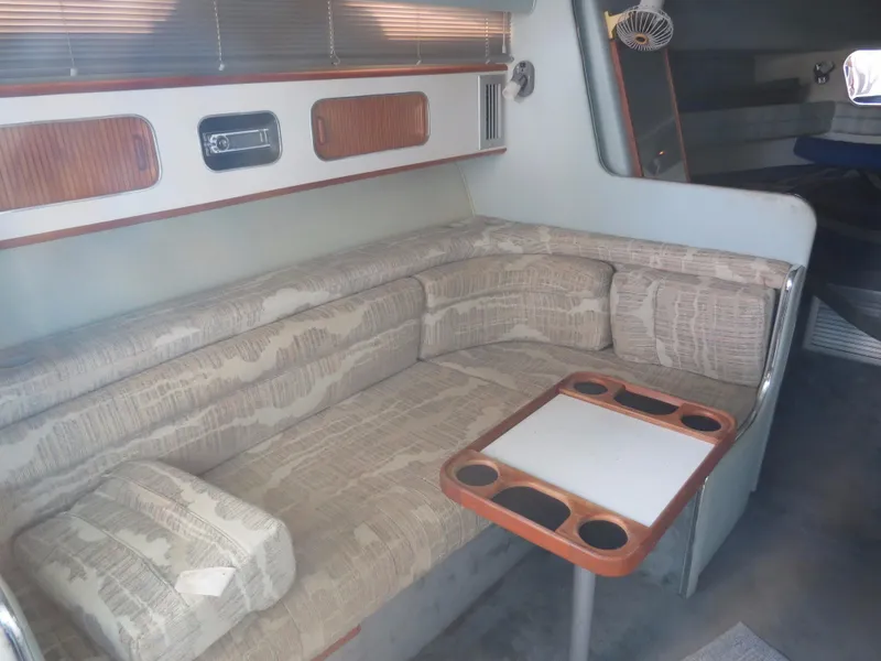 Slide: The Image of Interior of 1989 Sea Ray Sundancer 280 with beige seating and wooden table. - 12