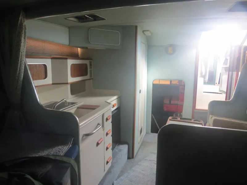 Slide: The Image of Interior of a 1989 Sea Ray Sundancer 280 boat, featuring a compact kitchen area. - 16