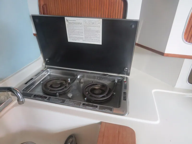 Slide: The Image of 1989 Sea Ray Sundancer 280 kitchen with dual-burner stove and sink. - 18